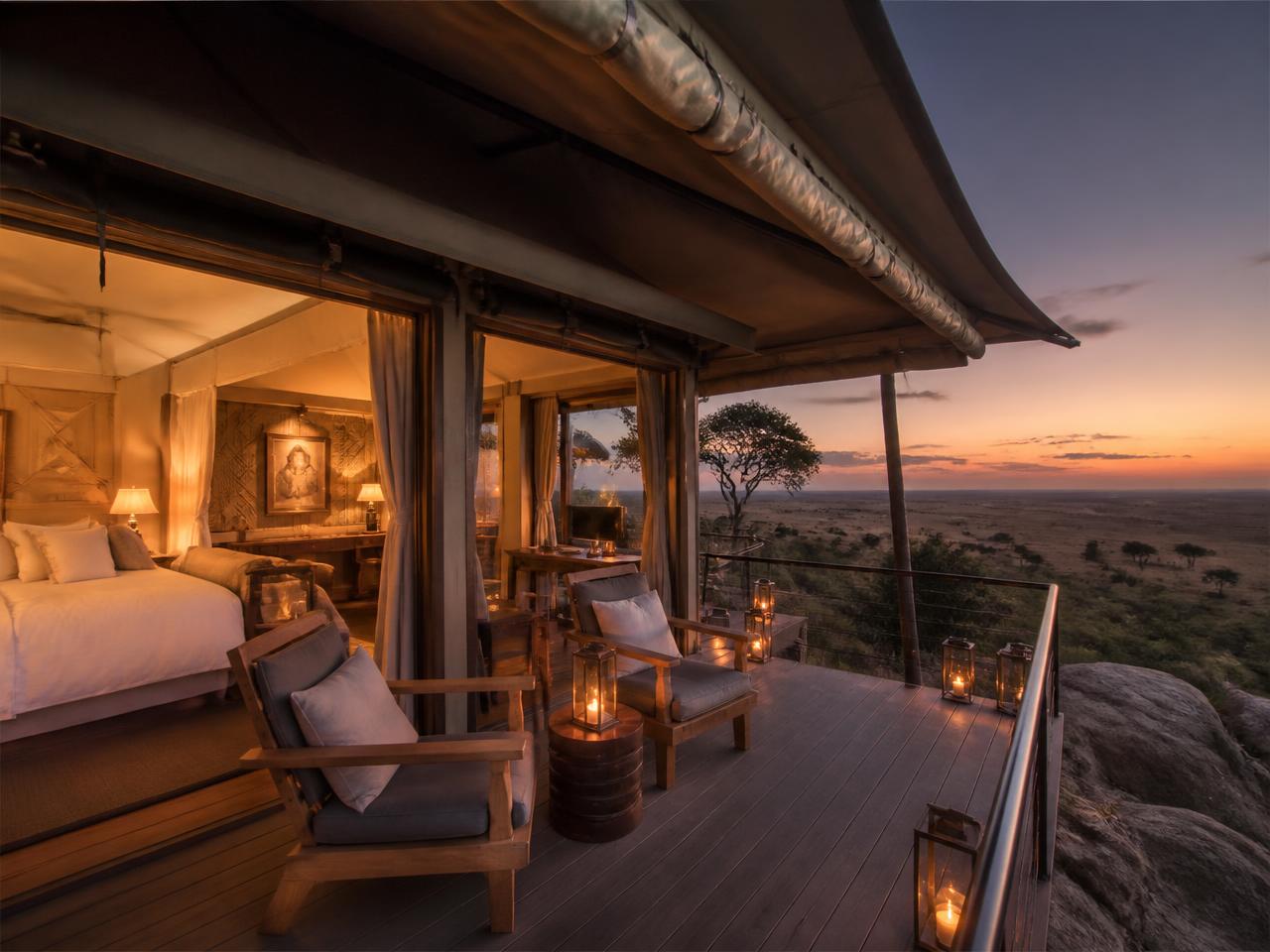 Luxury tented camp suite with a private deck overlooking the Serengeti at dusk